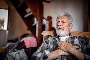 Senior man having trouble breathing at home