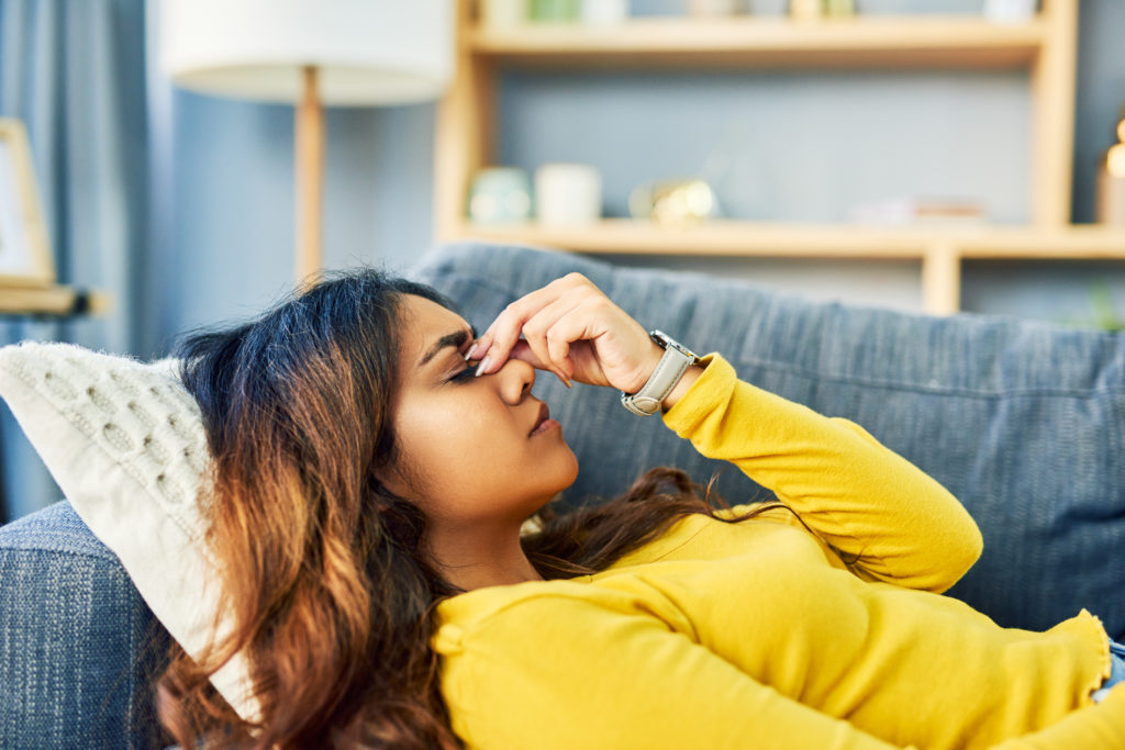 Woman with a bad headache laying on couch